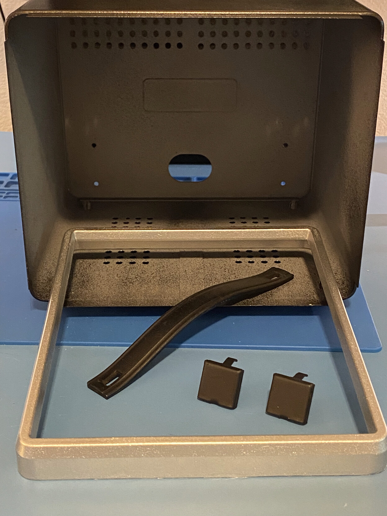 Front view of the same, showing the front panel frame, carrying strap, attachments and primer-grey case interior more directly.