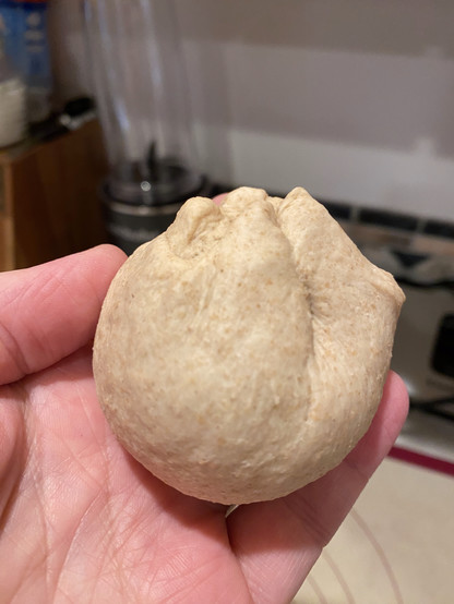 a ball of dough with the smooth end stretched out and the irregular bits pulled up to the top. a ball of dough with the smooth end stretched out and the irregular bits pulled up to the top.