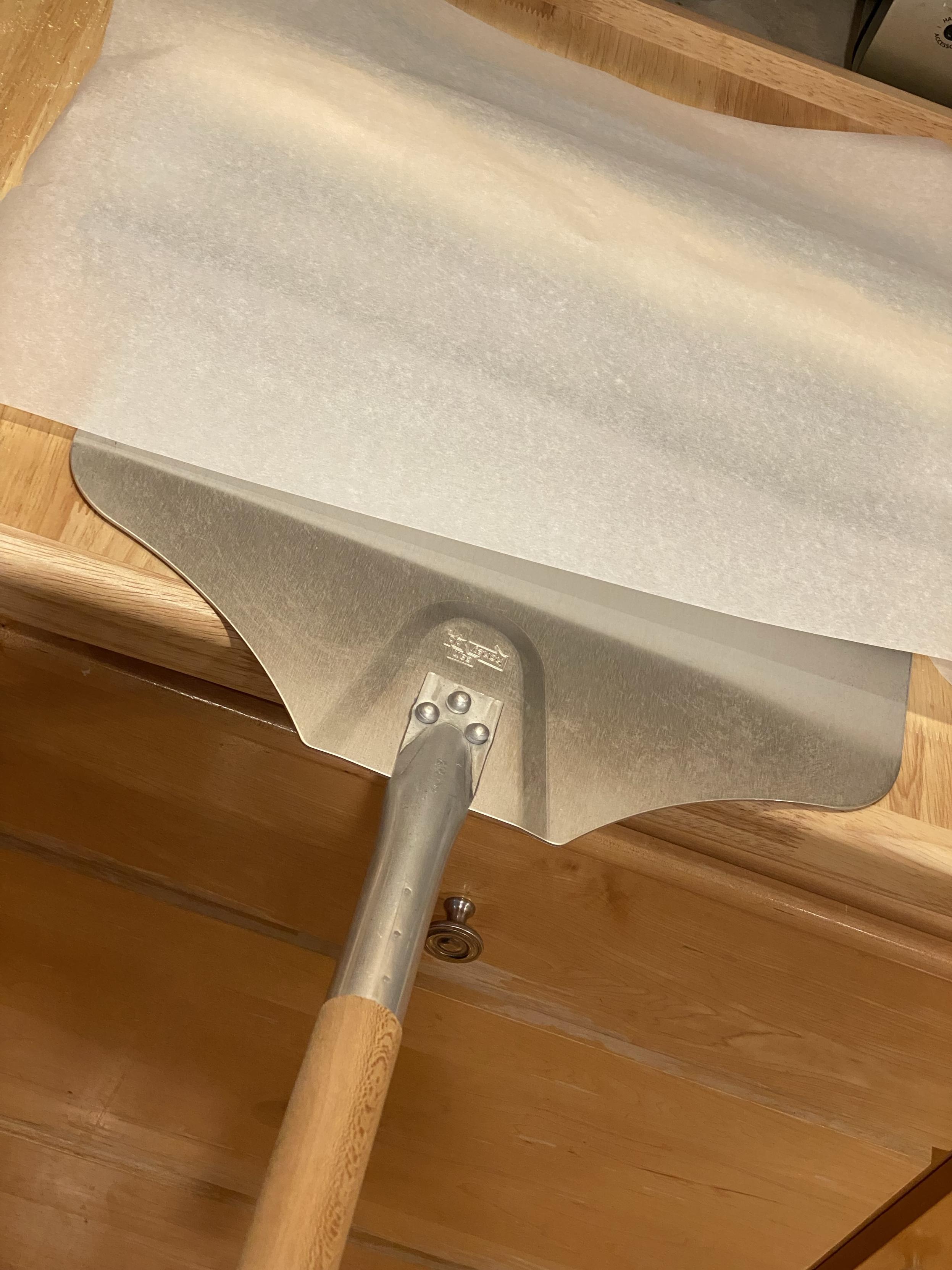 a giant metal oven spatula for lifting the weird baking tray into and back out of the oven. it’s under said tray and particularly covered by the parchment paper still covering the rising dough