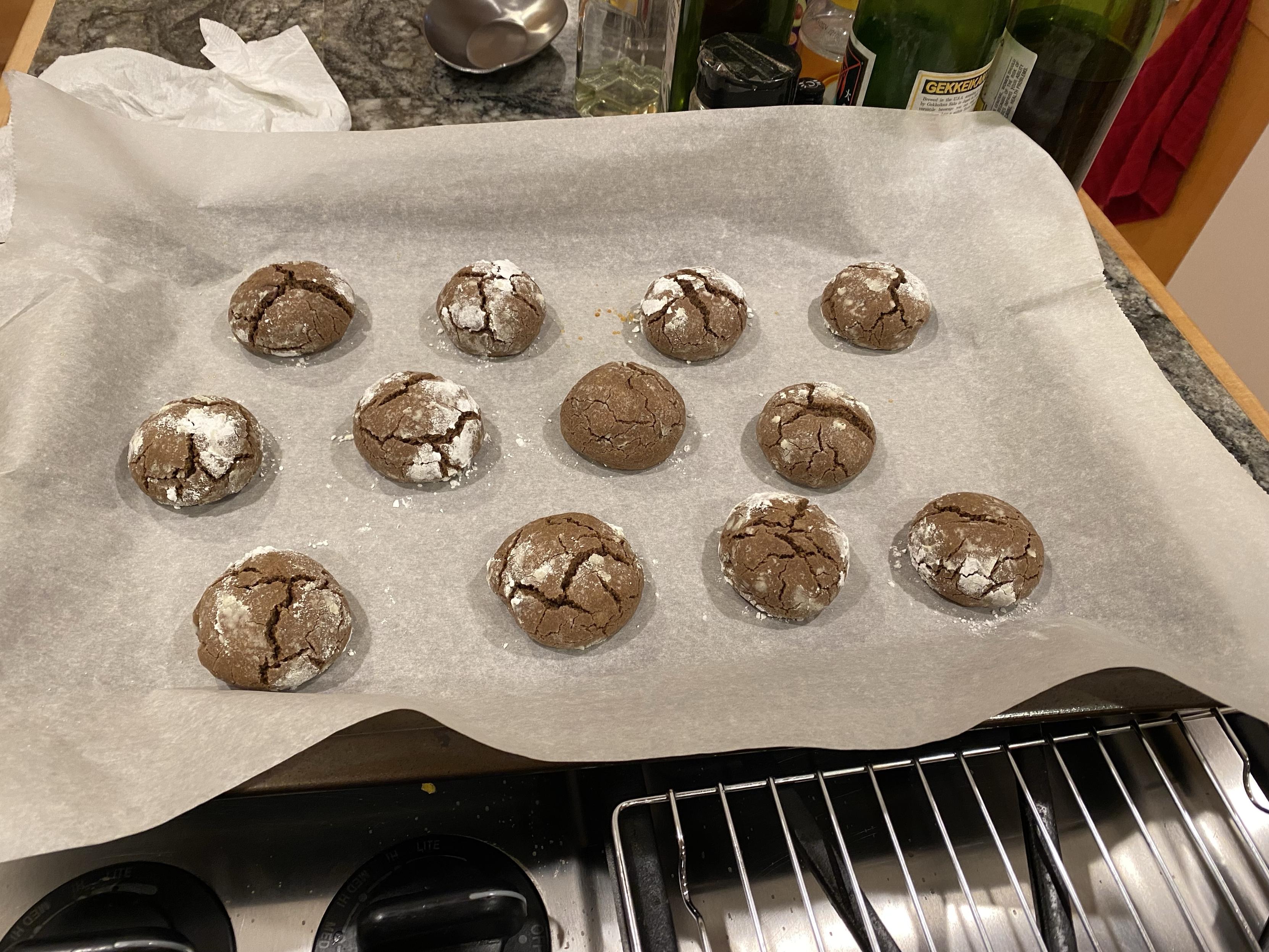 12 cookies flattened and looking way more cracked and less sugary out of the oven still on paper