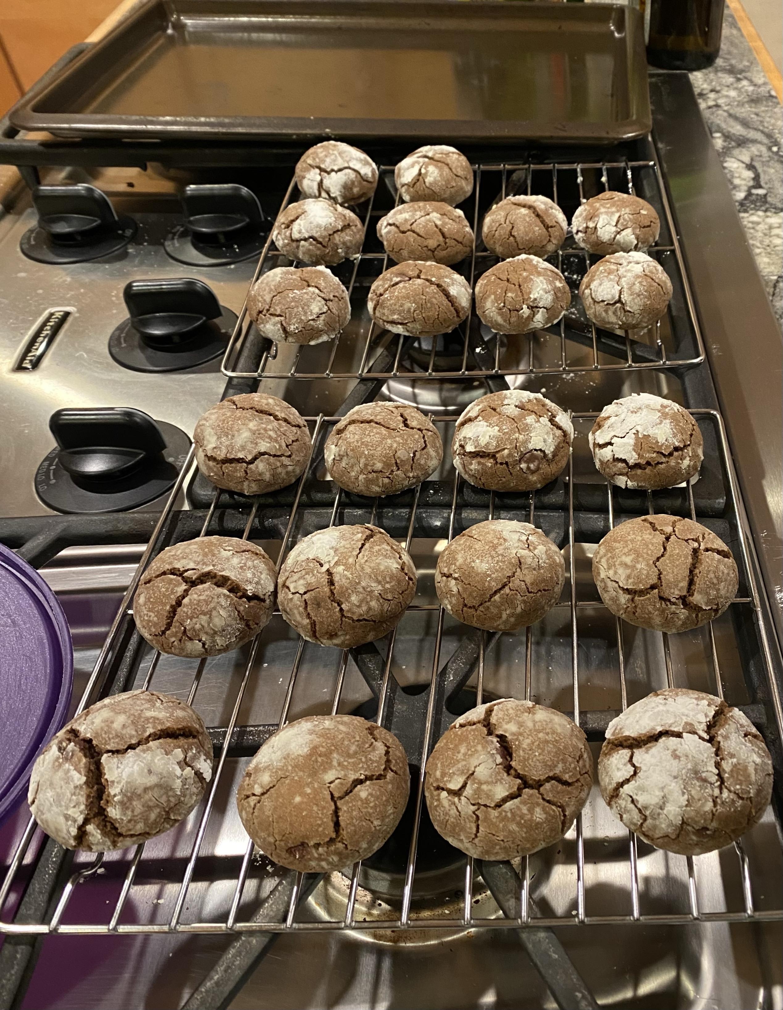 a long cooling rack of 22 remaining cookies cooling on a stovetop with a cookie sheet in the background