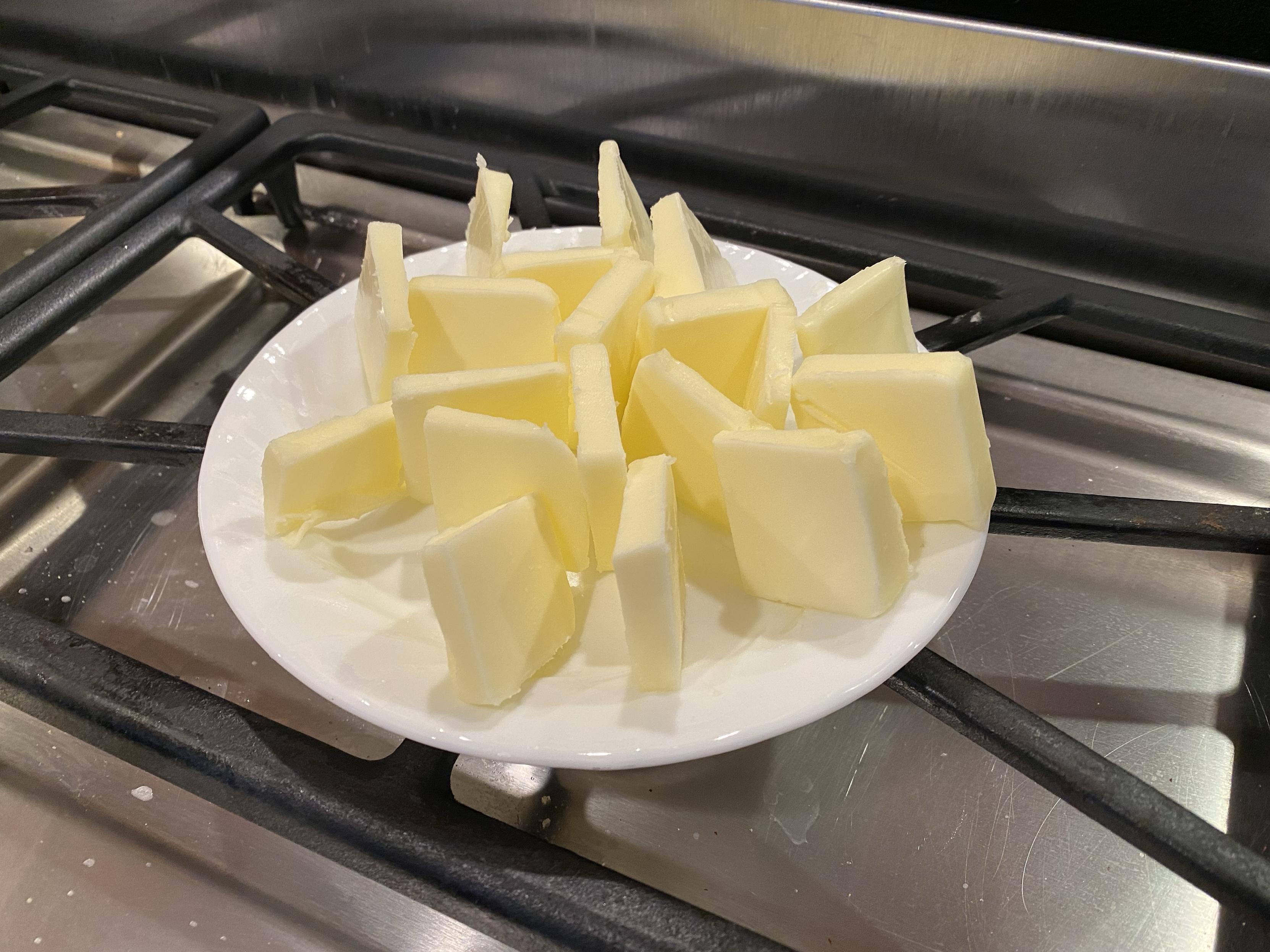 the butter sliced and stood up vertically on a plate resting on a heated up grill in front of a fan on very low to keep warmer air moving across the butter