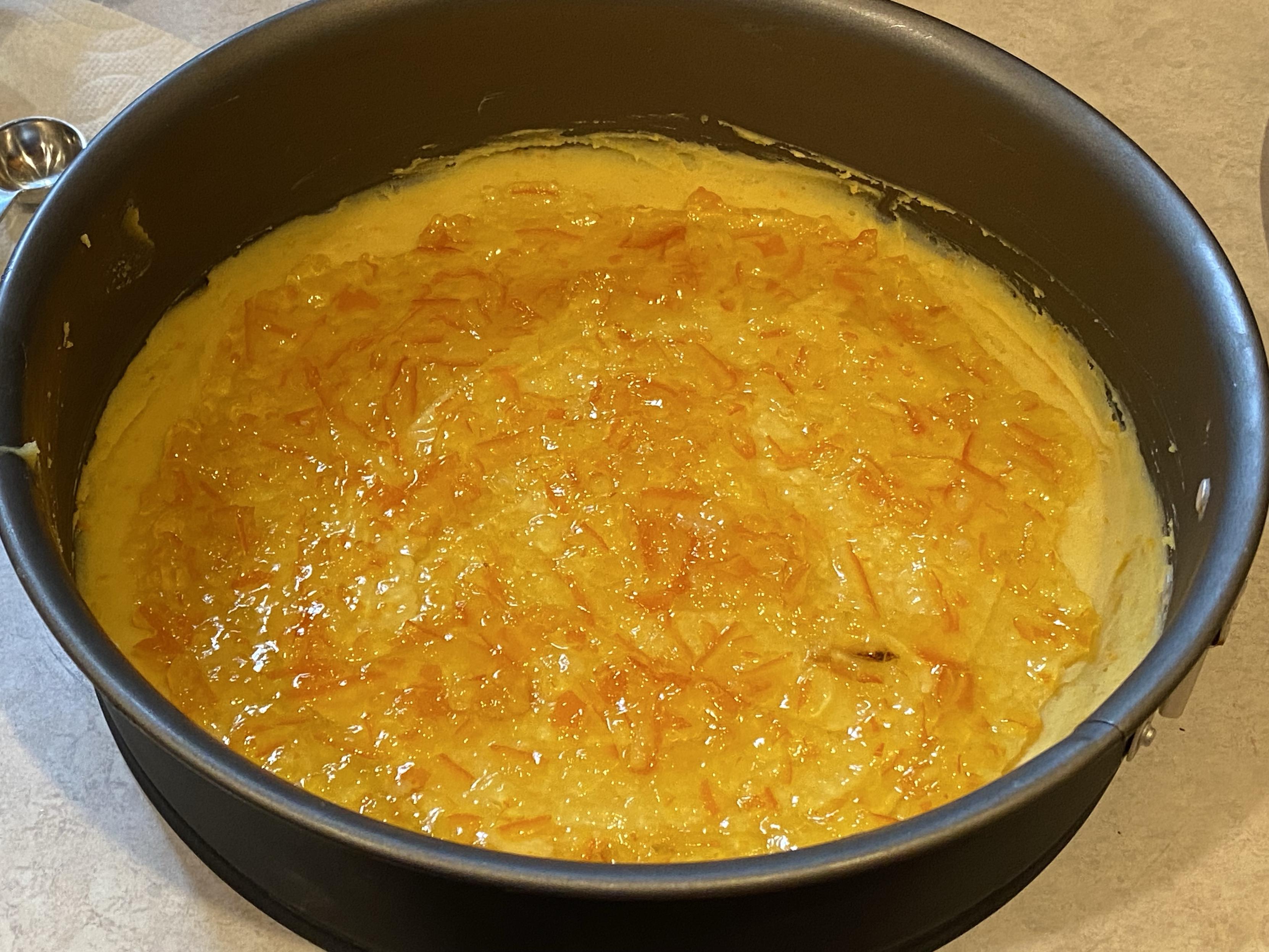 the previous layer of butter batter in a cake tin now with a layer of marmalade avoiding the outer edge, about to go back into the freezer again