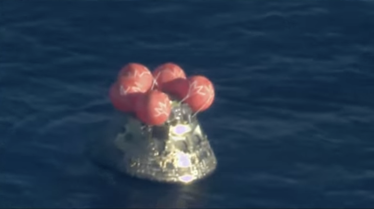 integrity capsule looking very, very sparkly as it floats in the ocean with its helium balloons deployed, waiting for the arrival of the "front porch" offboarding floating ramp