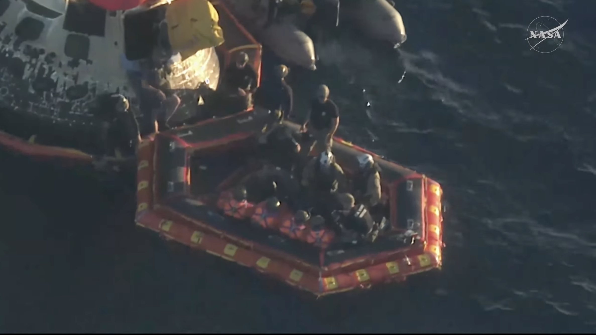 all four astronauts clearly visible on the "front porch" floaty boat, about to be moved by helicopter to the john p murtha