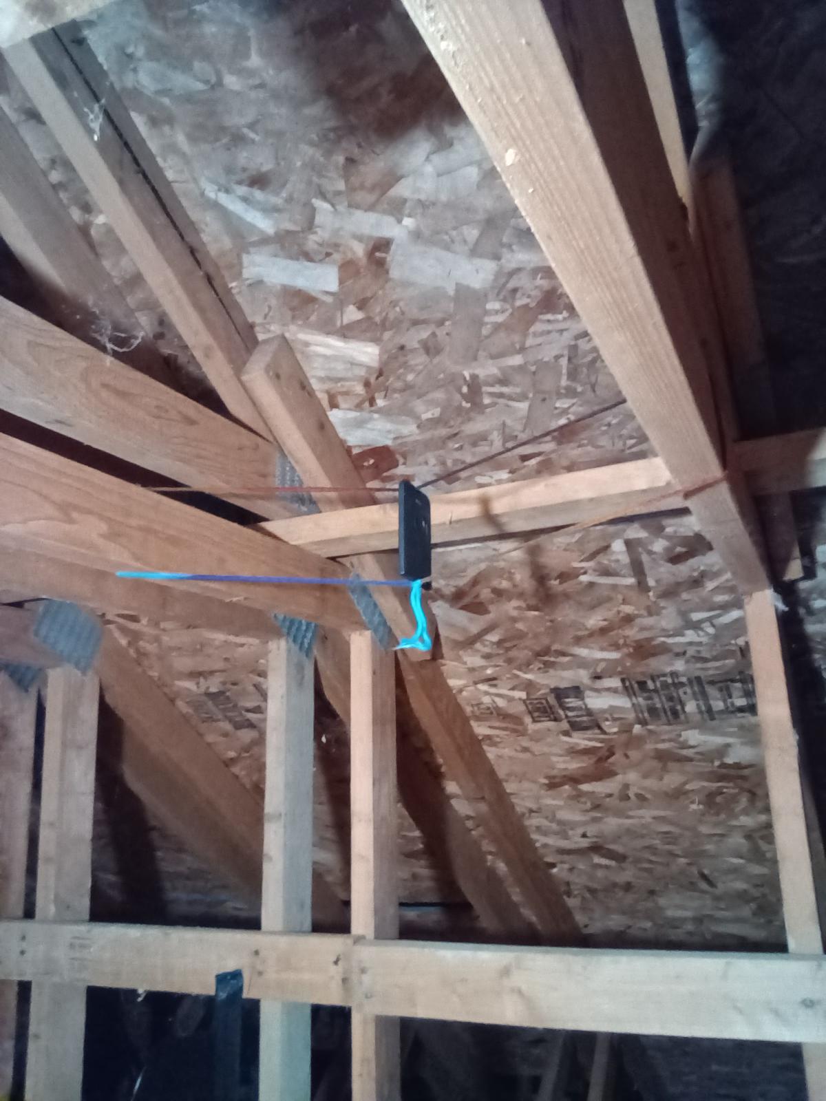 a rakmesh tag the size of a debit.card hanging.off cord strung between beams.in an attic