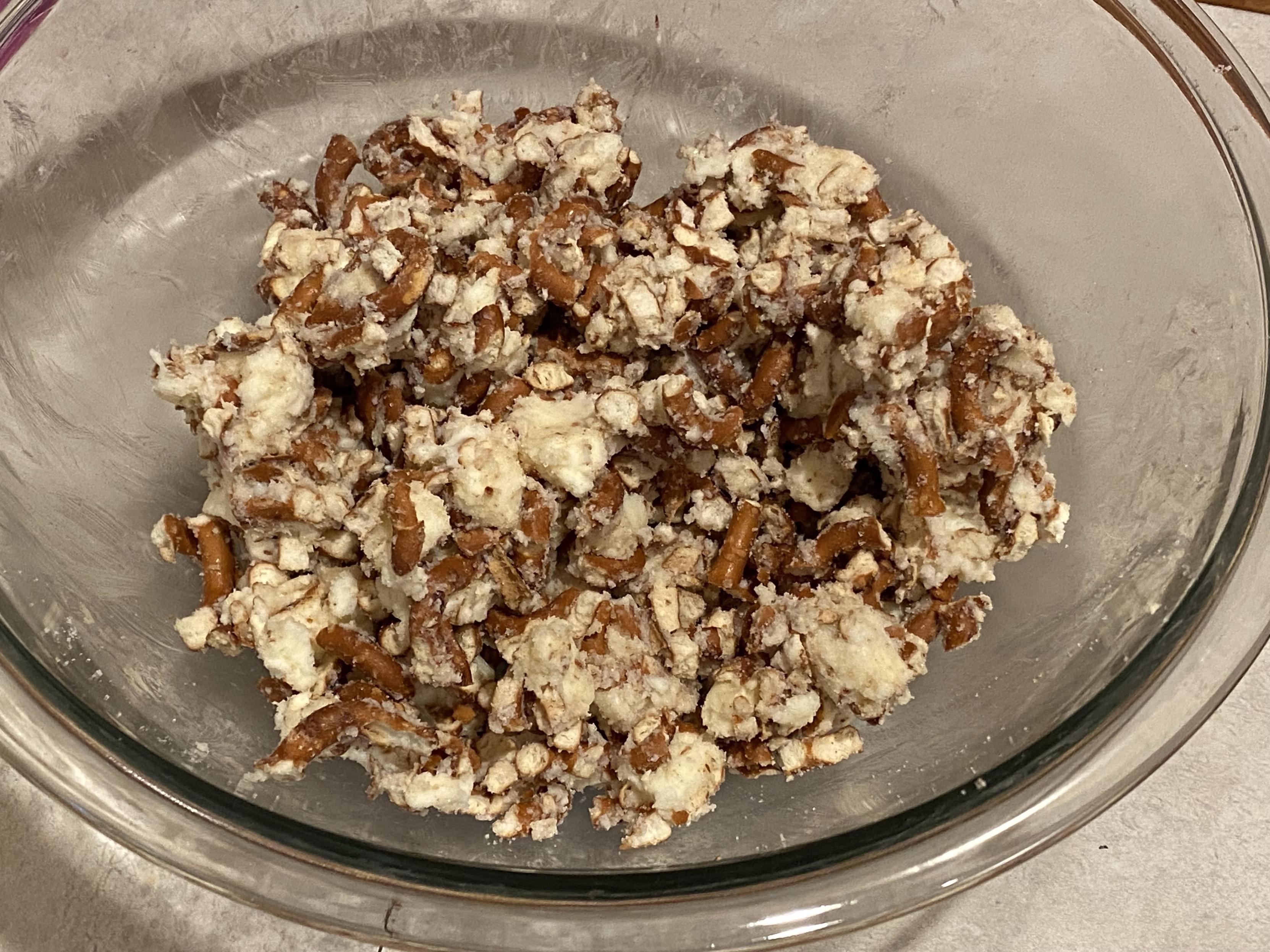 a smoosh up of pretzel bits, butter, and sugar in a clear glass bowl