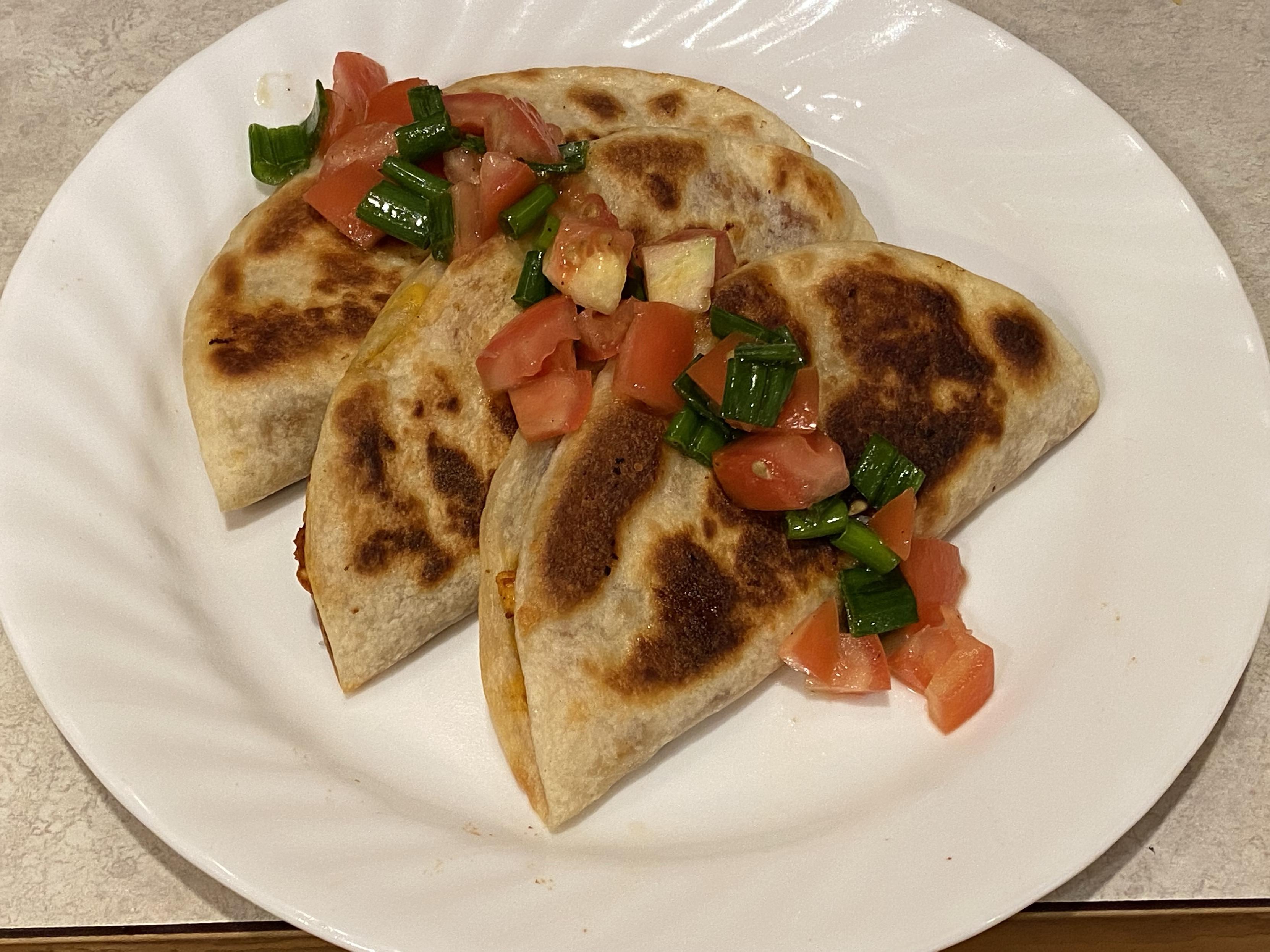 three tacos with pico de gallo on a white plate