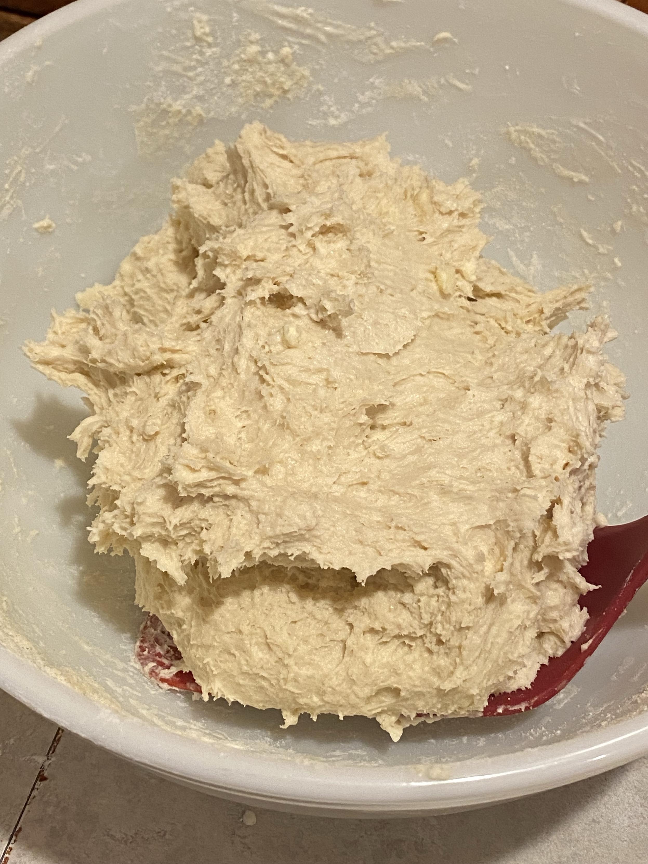 a very shaggy dough in a big white bowl with a spatula