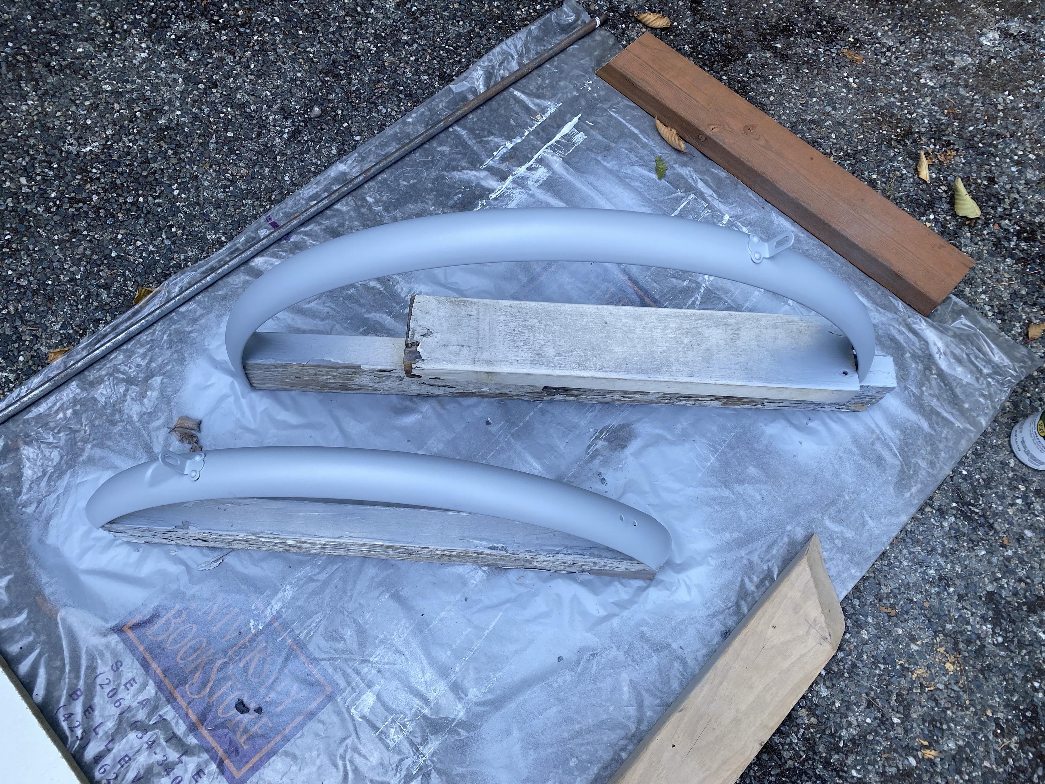 two metal schwinn bike fenders, heavily rusted then de-rusted, covered with rust protection primer
