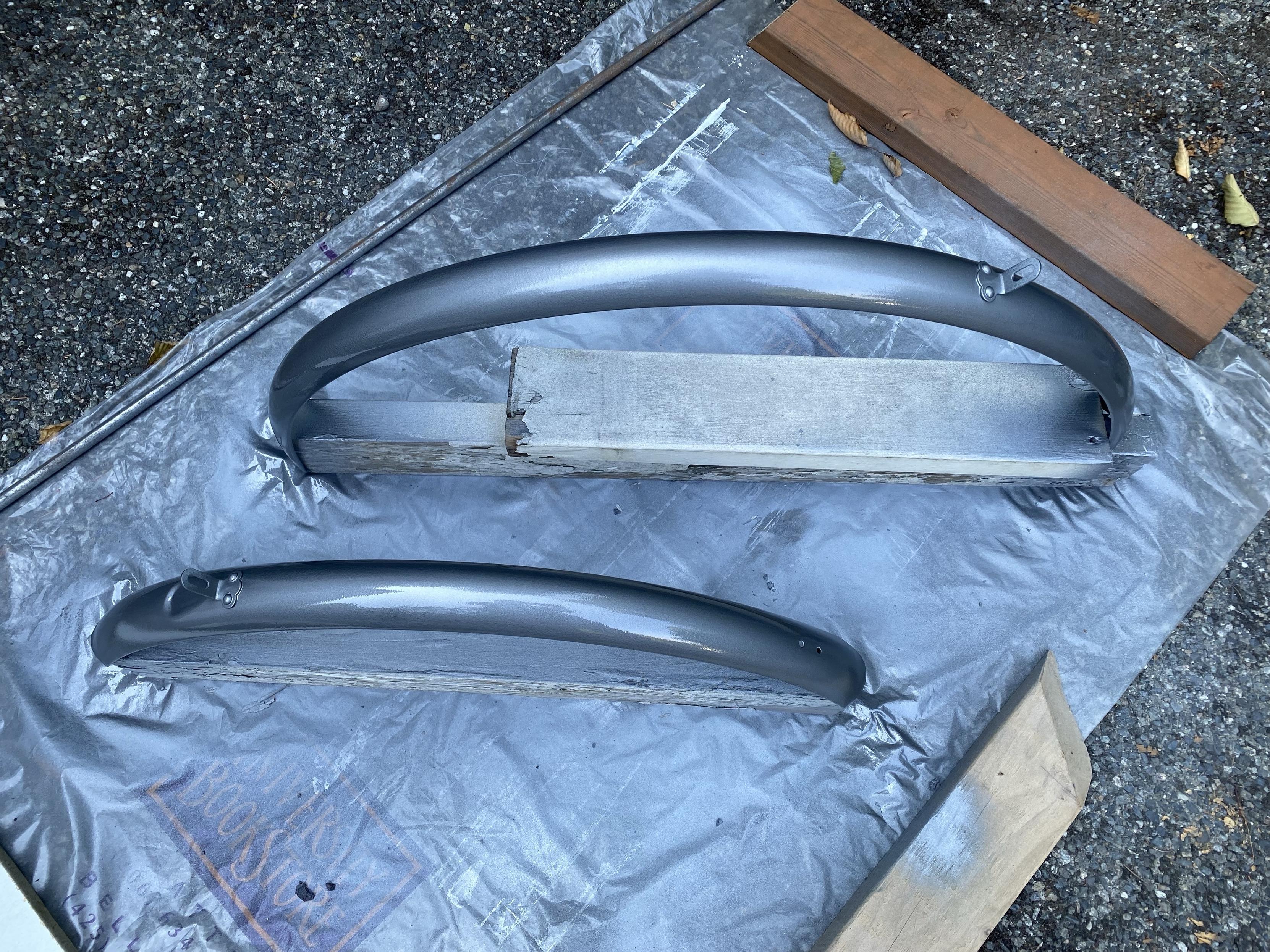 the same two metal schwinn bike fenders now covered with a coat of hammer finish silver/grey paint